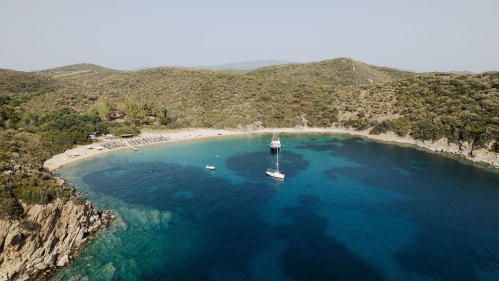 Private boats anchored at Ammouliani Island, Halkidiki — a stop on the Premium 6-7 hour cruise from Vourvourou with Explore Boat Trips