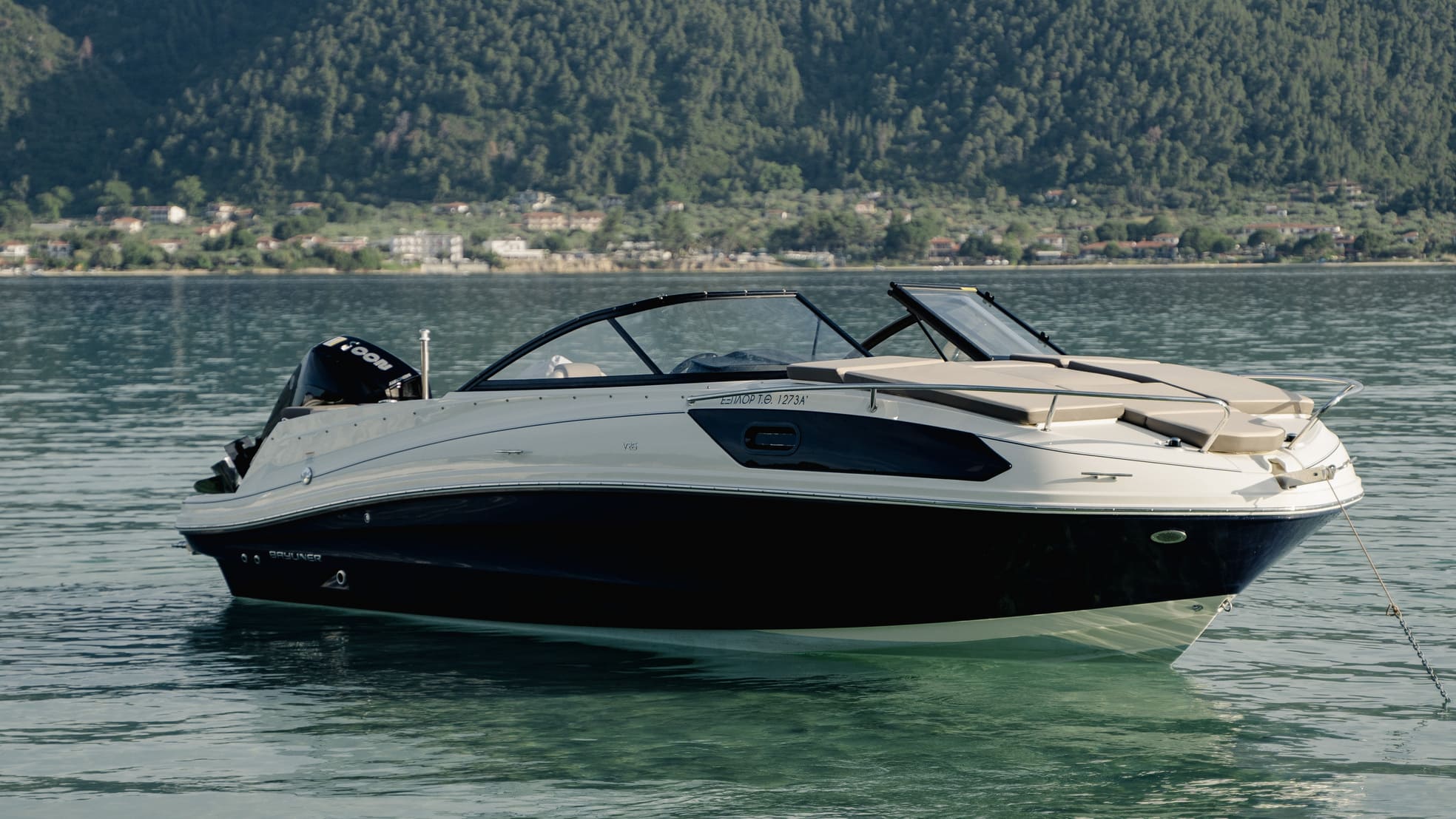 a small boat in a body of water with a mountain in the background